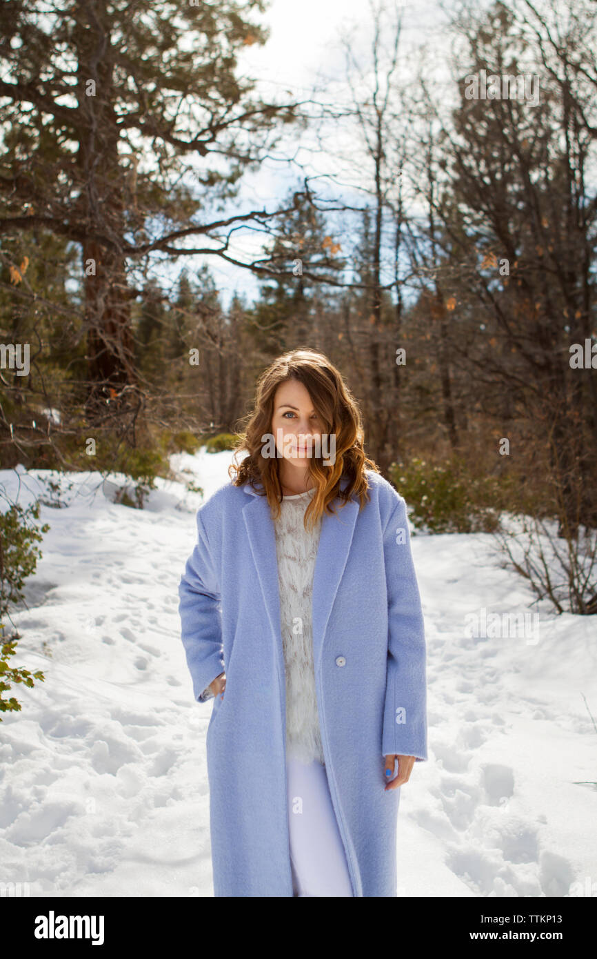 Portrait of beautiful woman standing on snowy path Stock Photo - Alamy