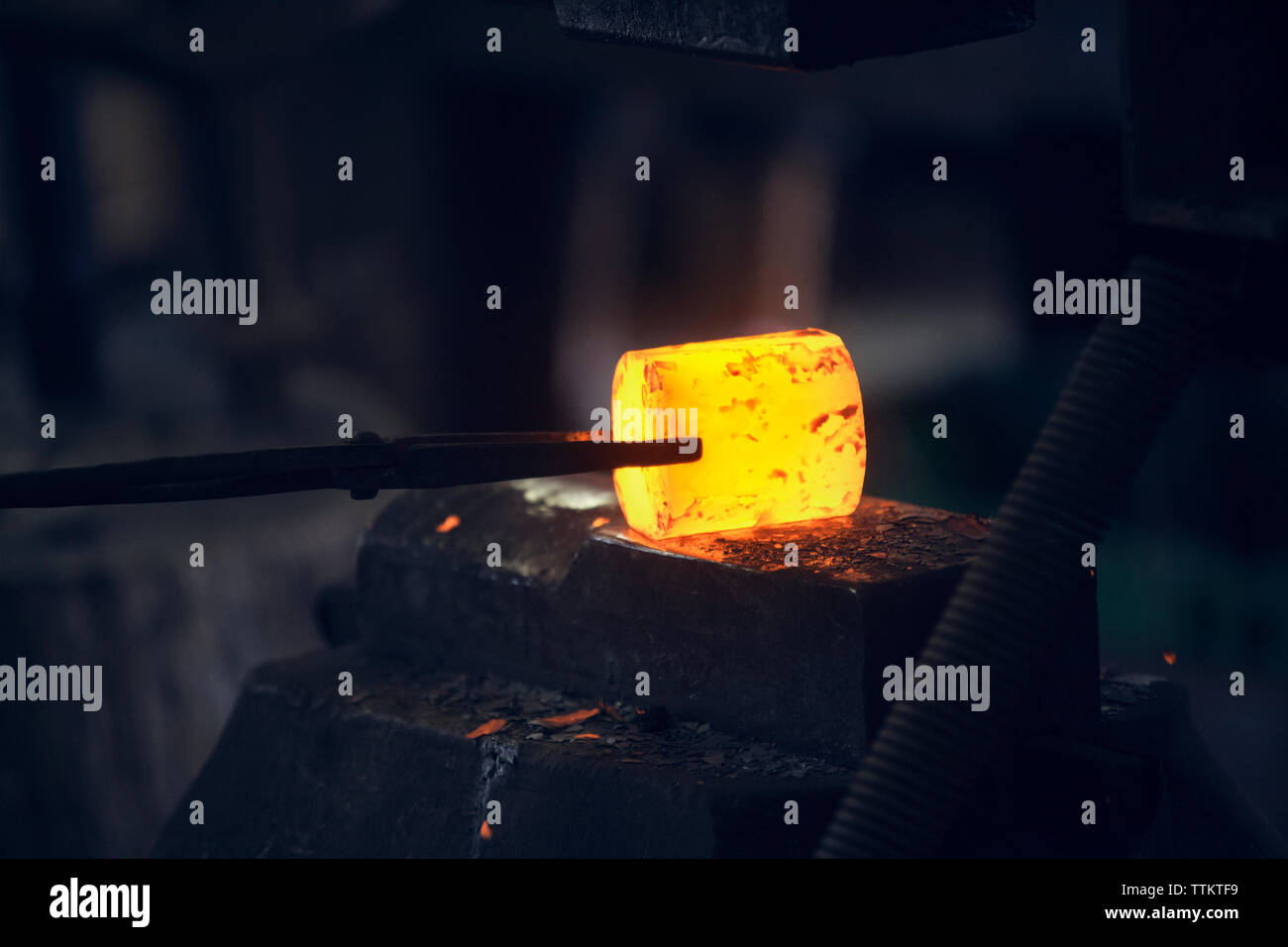 Glowing heated metal held by tongs in metal industry Stock Photo Alamy
