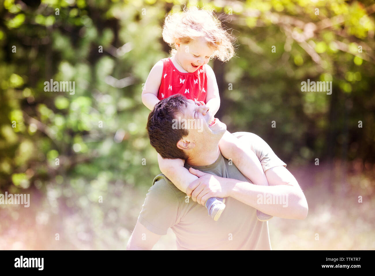 Happy father carrying daughter on shoulders at park Stock Photo - Alamy