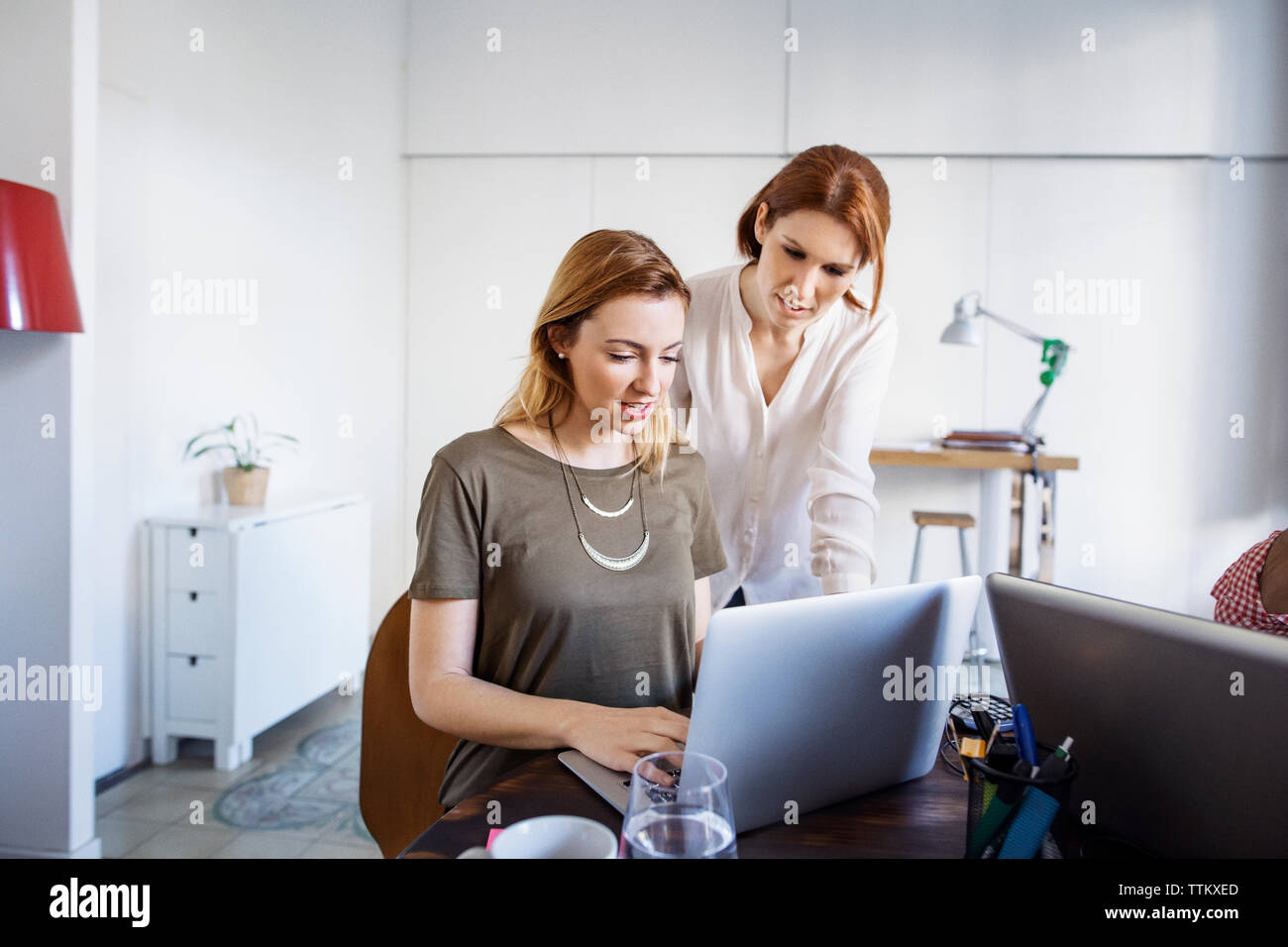 businesswomen working on laptop in creative office Stock Photo