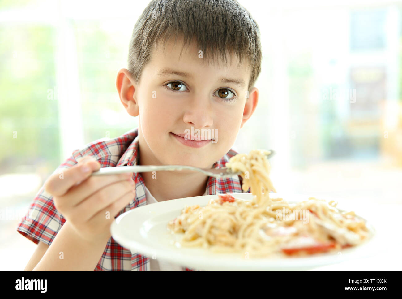 Cute boy eating spaghetti on kitchen Stock Photo - Alamy