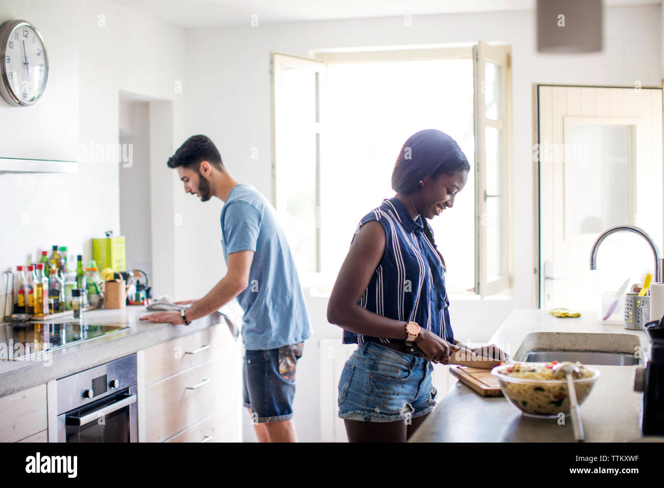 Side view of couple working in kitchen Stock Photo