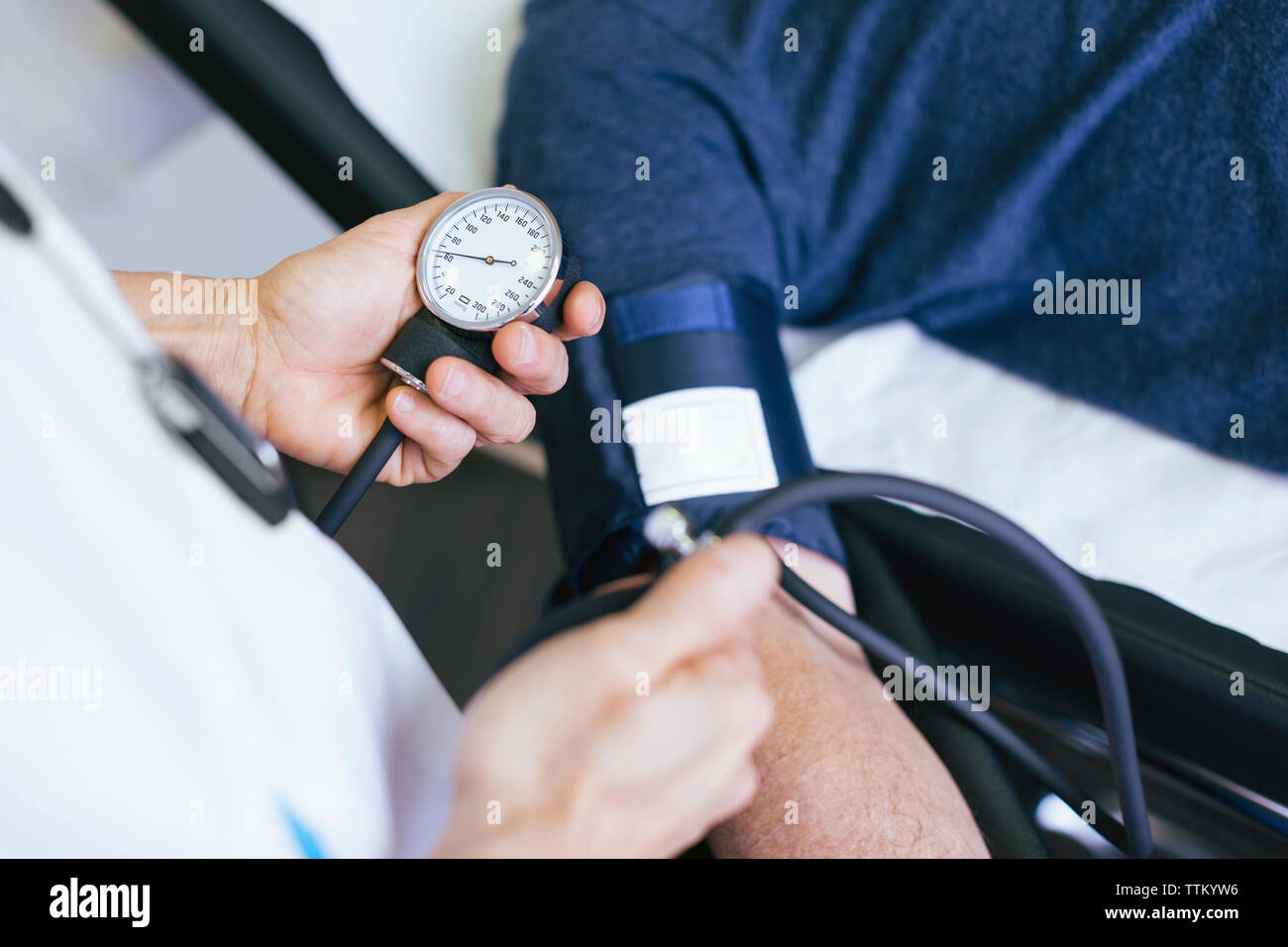 Close-up of doctor checking patient blood pressure at hospital Stock Photo