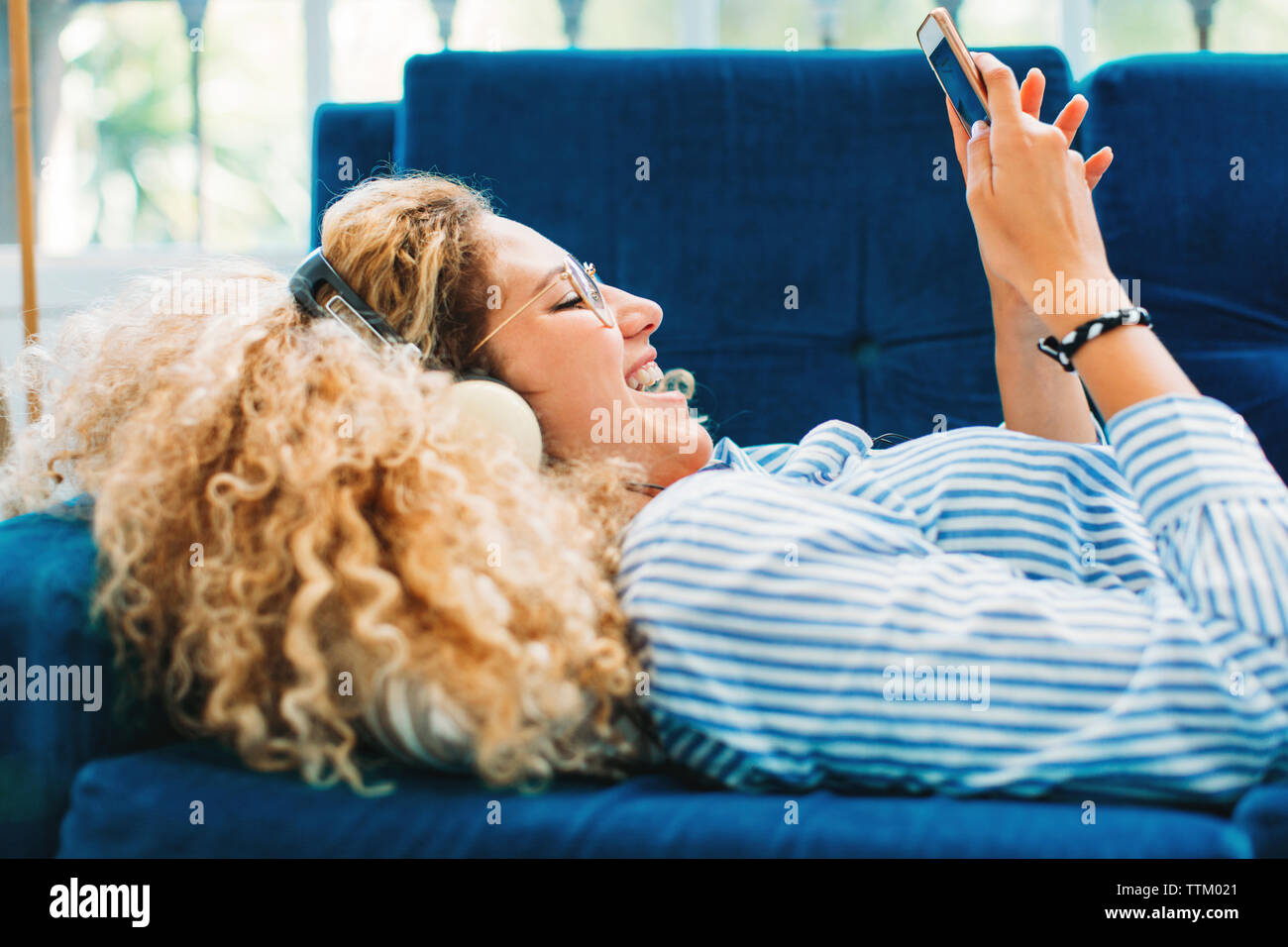 Blond woman lying on sofa hi-res stock photography and images - Alamy