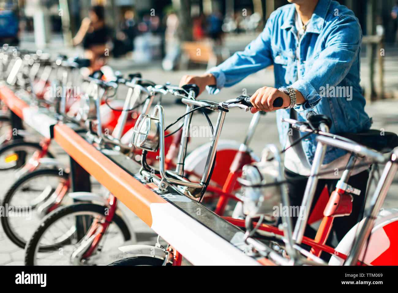 Midsection of man renting bicycle on street Stock Photo