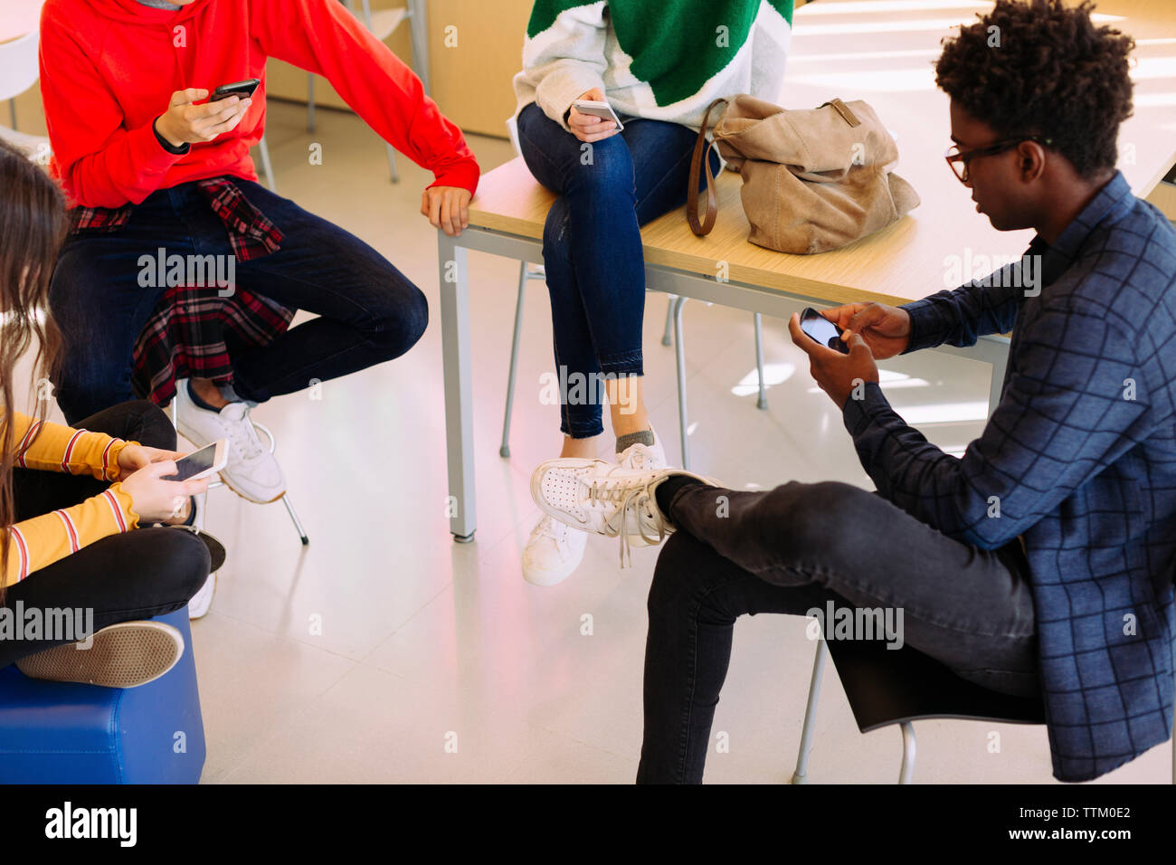 High angle view of students using mobile phones while sitting in library Stock Photo