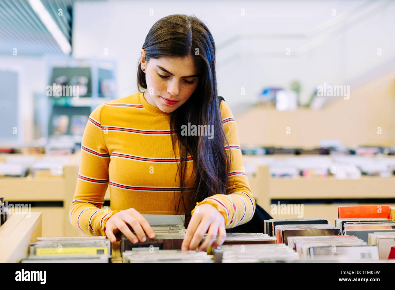 Woman searching book in shelf at library Stock Photo