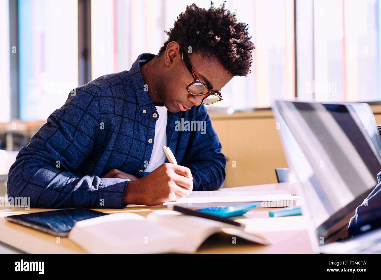 Person writing at desk deals