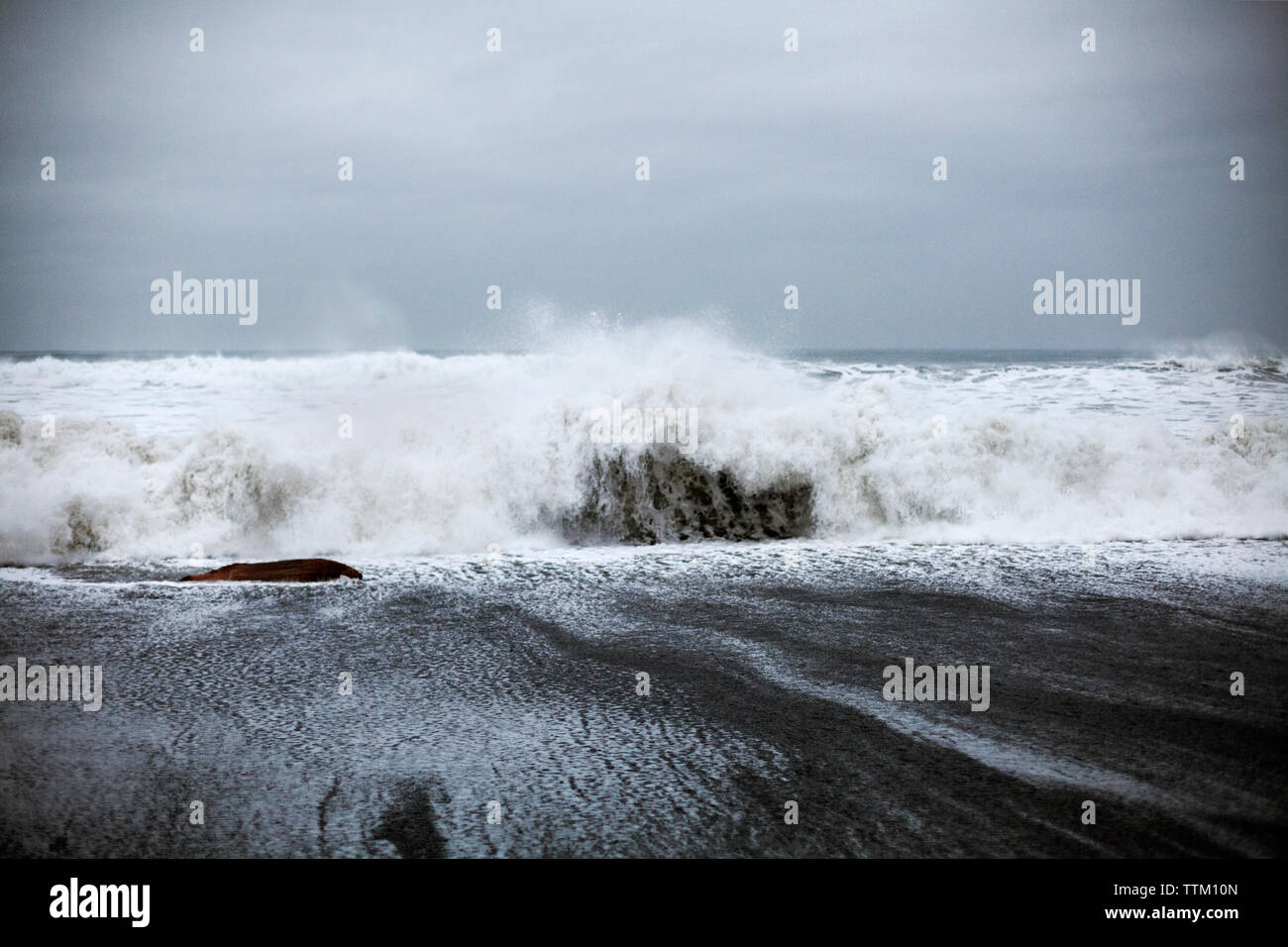 Waves crashing on shore against sky Stock Photo