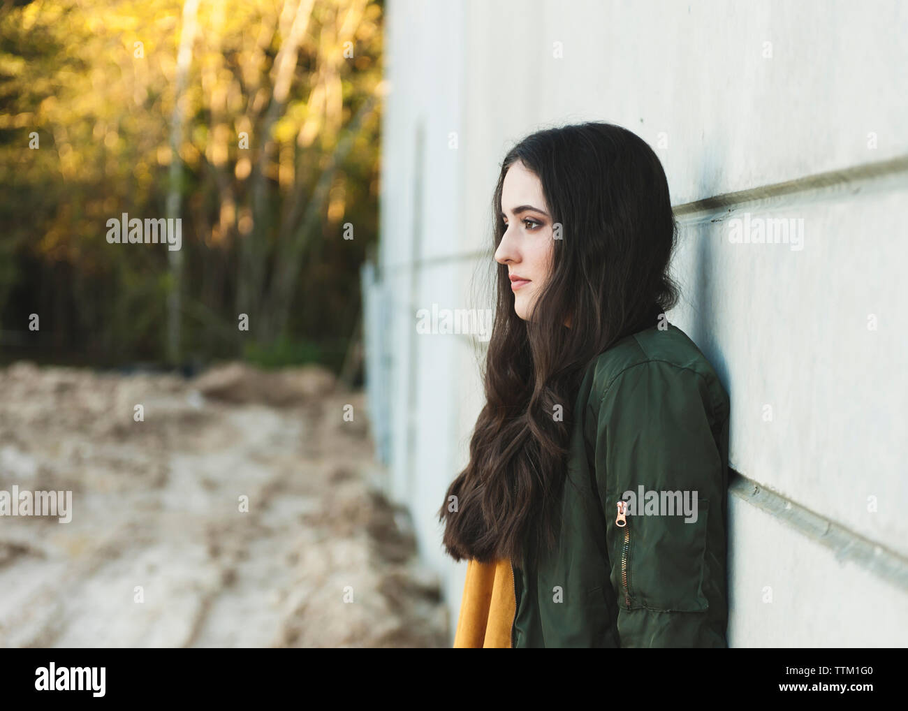 Side view of thoughtful teenage girl looking away while standing ...