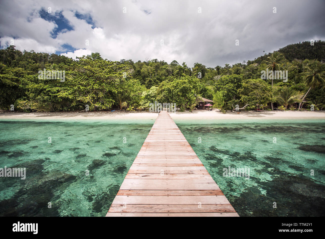 View of pier at Raja Ampat Islands against cloudy sky Stock Photo