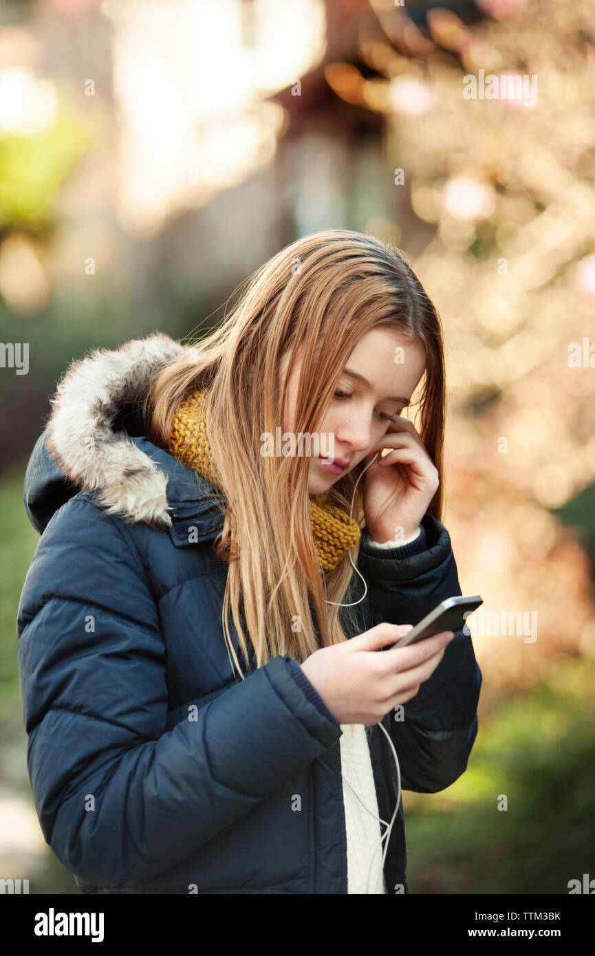 Girl wearing headphones and using smart phone Stock Photo