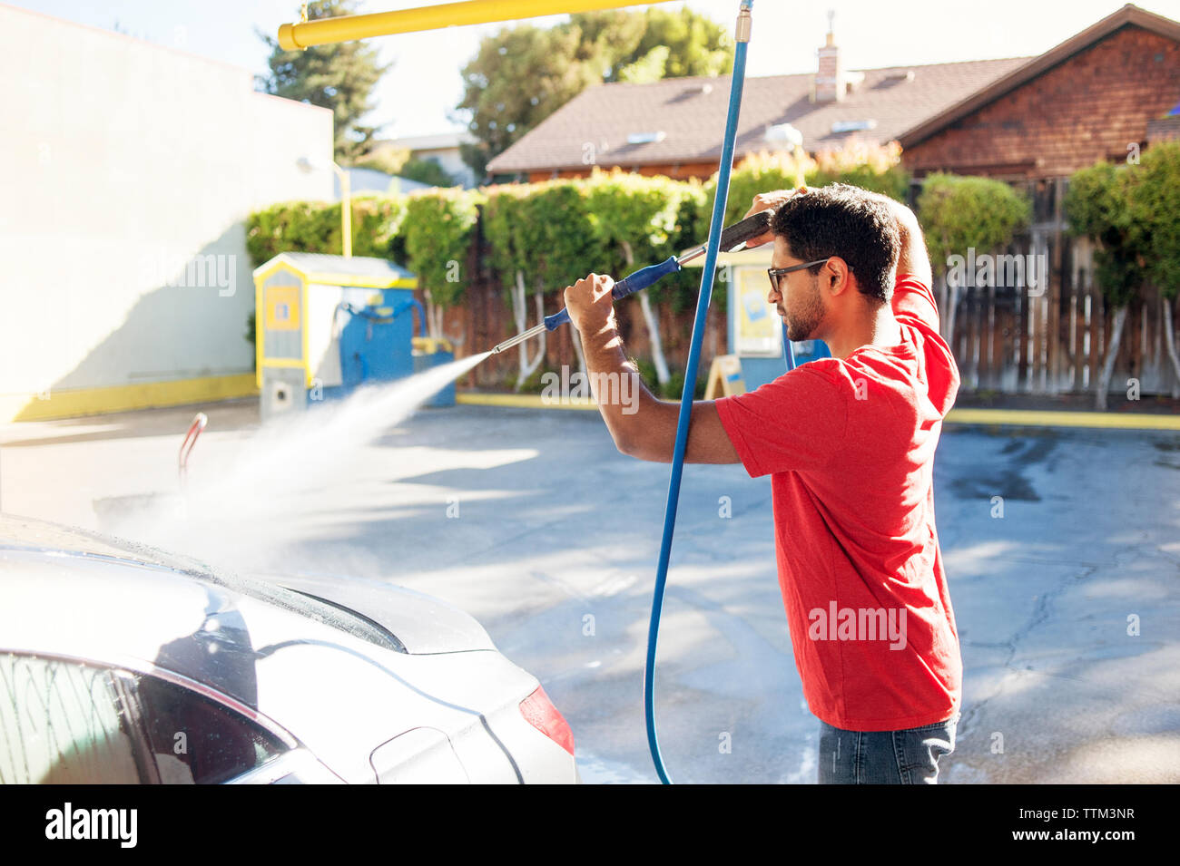 Man cleaning car at driveway Stock Photo