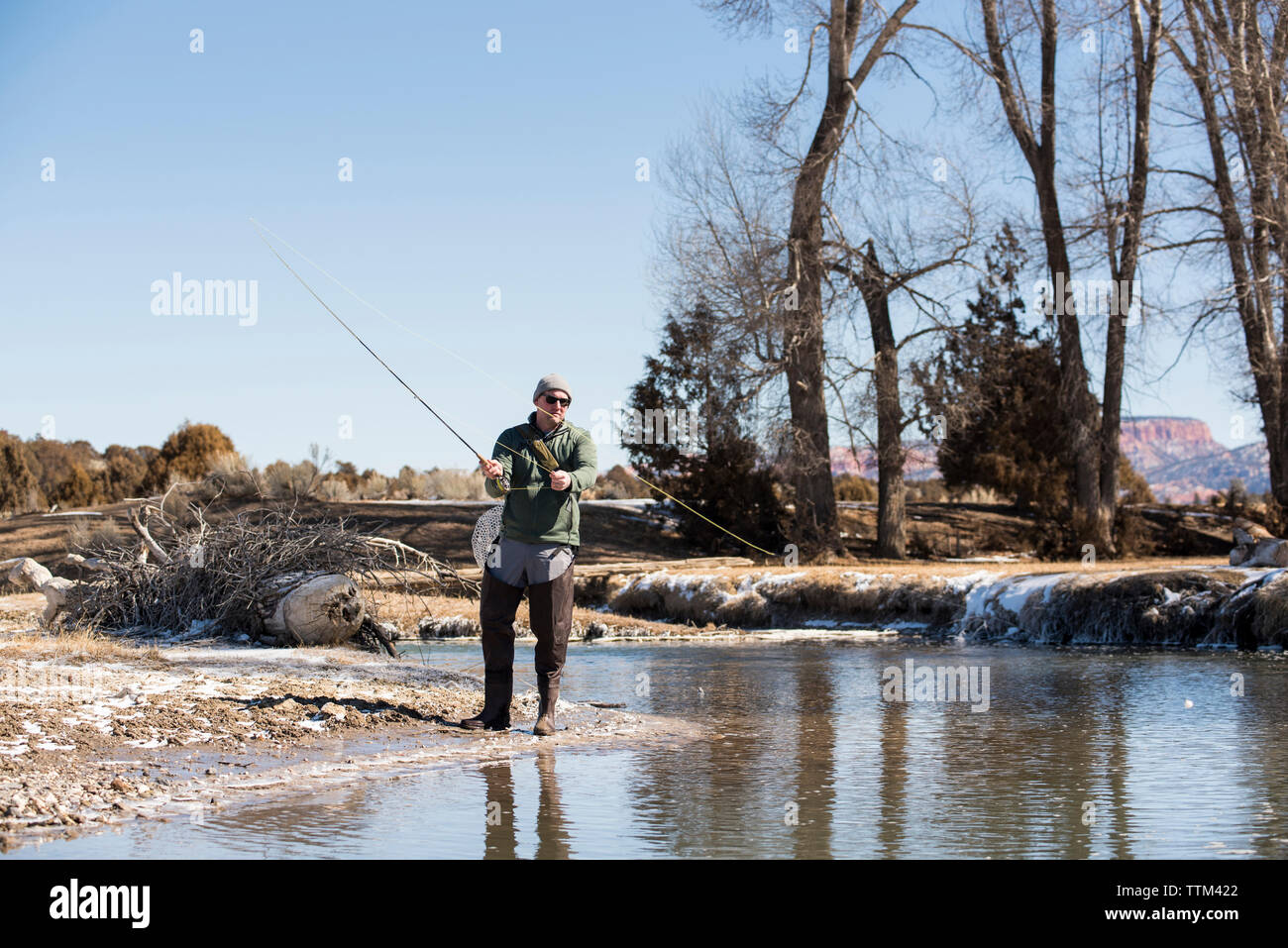 Full length of man fishing in river against clear sky Stock Photo