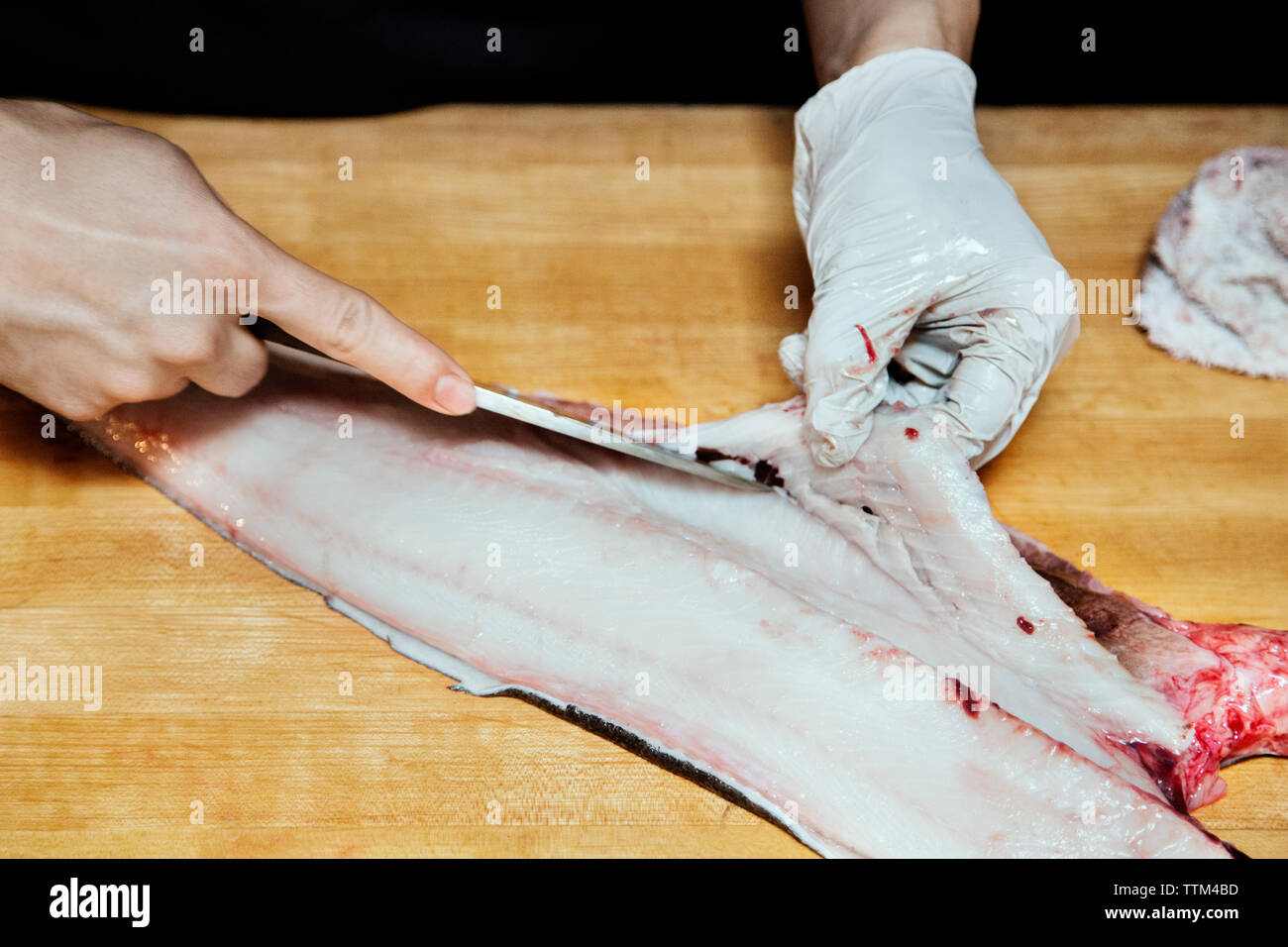 Close-up of chef cutting fish on cutting board Stock Photo