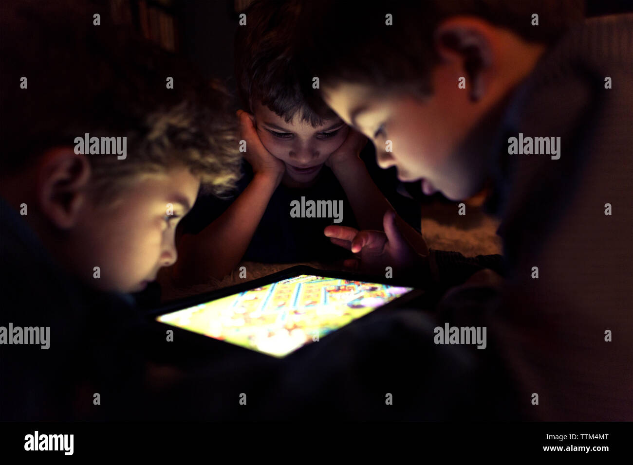 Siblings playing game on tablet computer at home Stock Photo