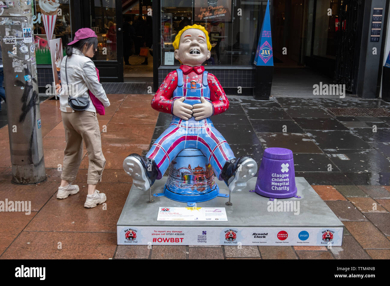 Glasgow, Scotland, UK. 17th June, 2019. Life In Glasgow, created by Taylor McTaggart. This statue shows Oor Wullie dressed in his dungarees, proudly representing the College tartan. His shirt also features the many subjects the College Offers, while his bucket depicts the very best of life in Glasgow. The sculpture is part of Oor Wullie’s BIG Bucket Trail. Credit: Skully/Alamy Live News Stock Photo