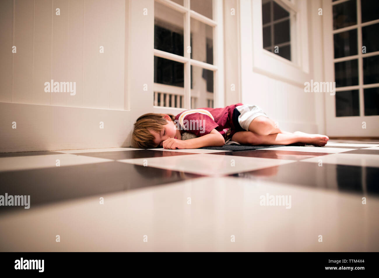 Boy sleeping on floor Stock Photo
