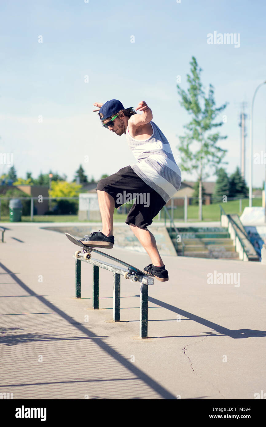 Young man skateboarding on railing Stock Photo Alamy