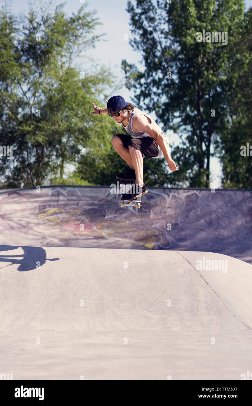 Young man doing skateboard trick on ramp Stock Photo