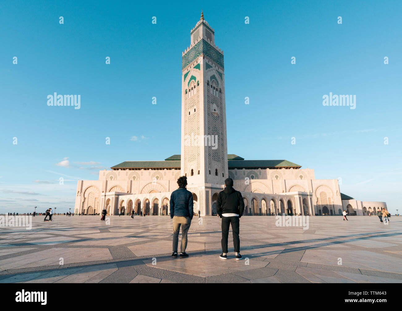 Rear view of friends standing against Mosque Hassan II Stock Photo