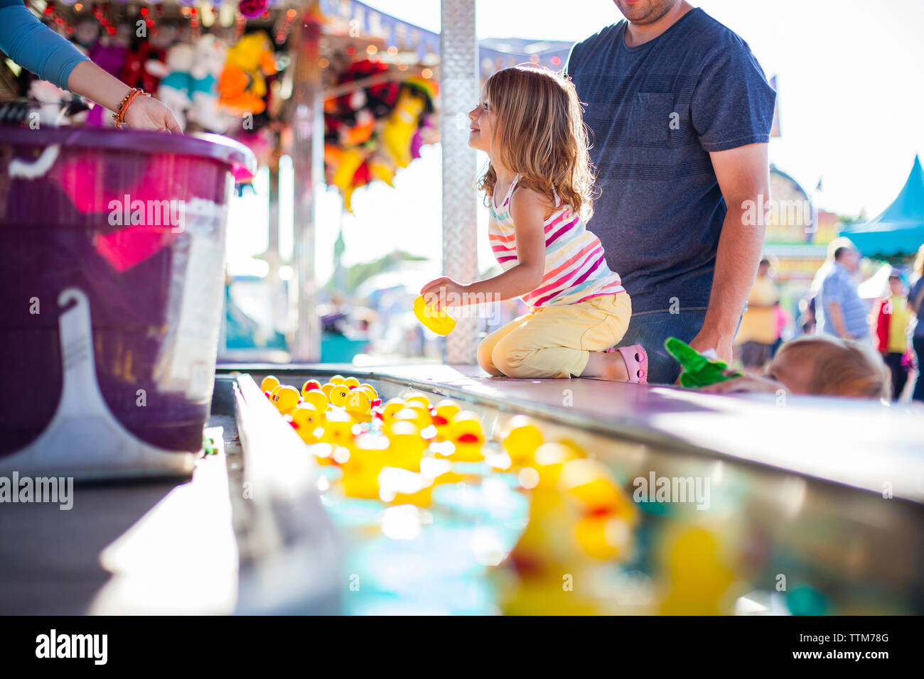 Father with daughter holding rubber duck while enjoying in amusement park Stock Photo