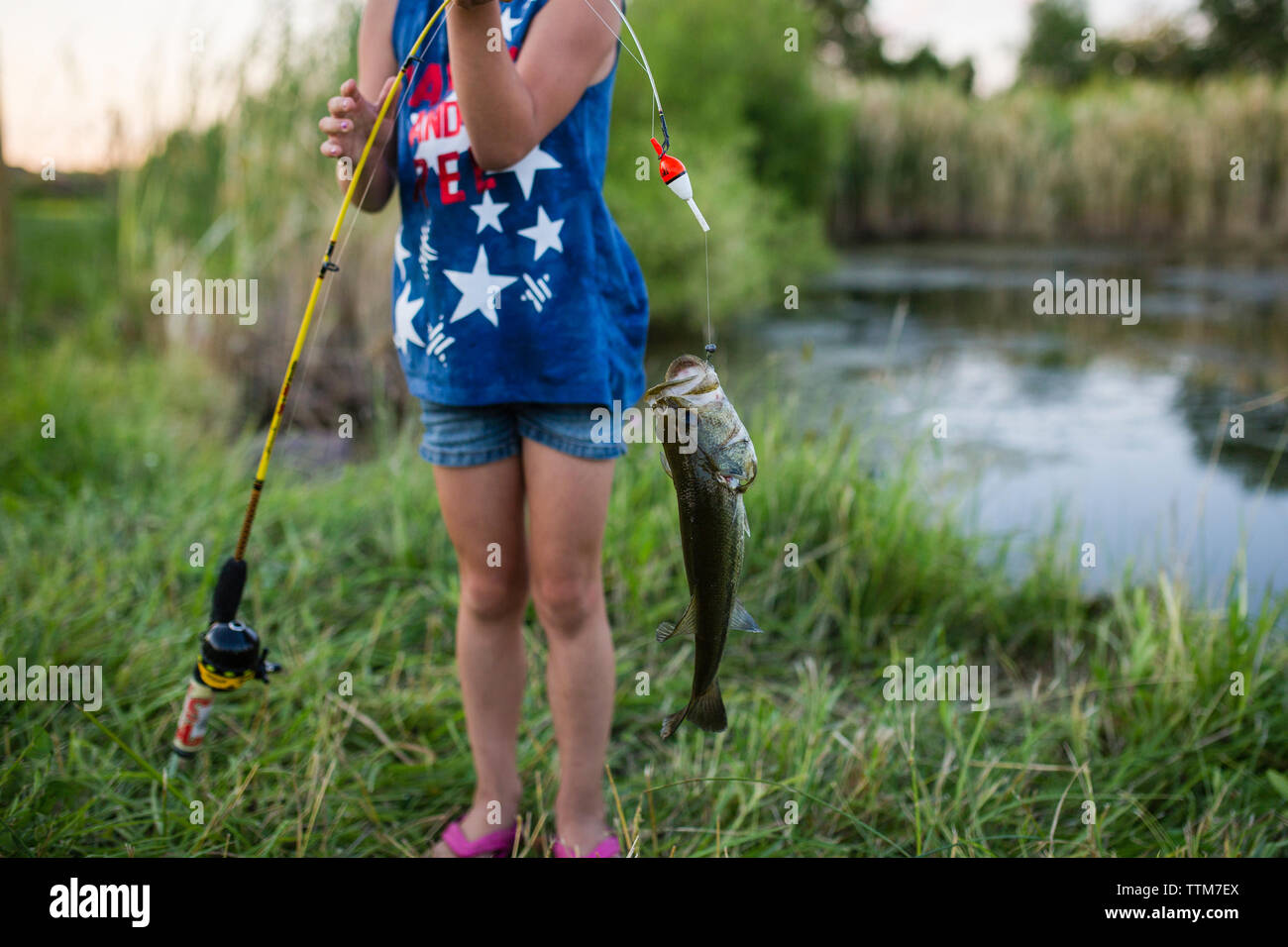Girl holding fish fishing rod hi-res stock photography and images