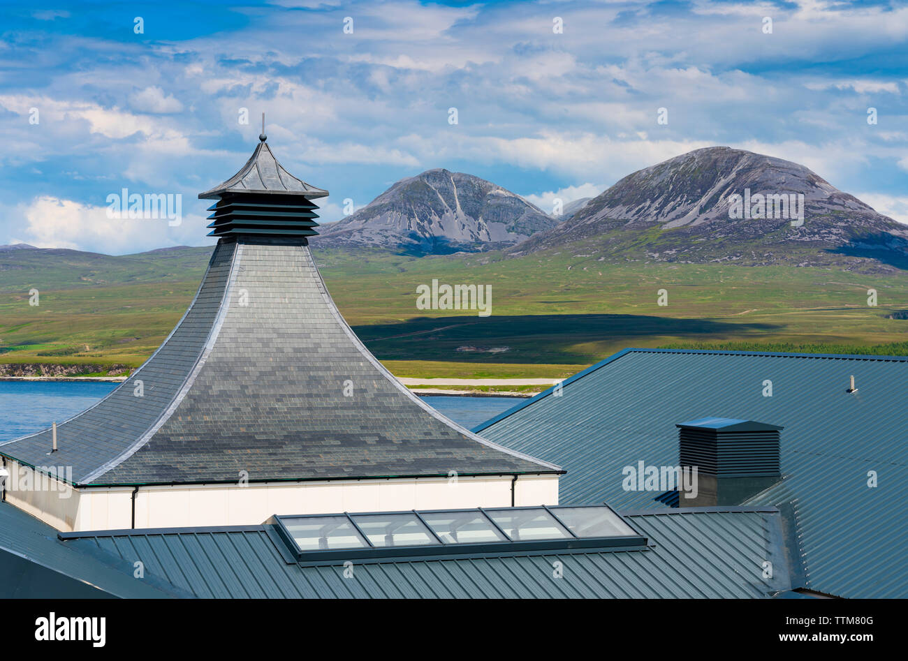View of new Ardnahoe Distillery on island of Islay with Paps of Jura mountains to rear in Inner Hebrides of Scotland, UK Stock Photo