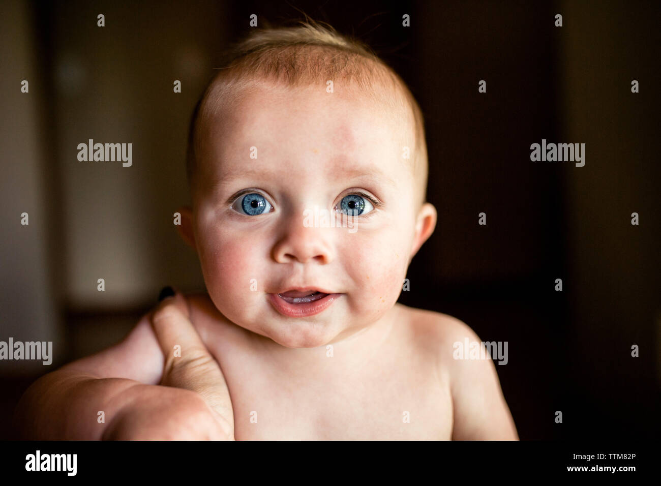 Close up of baby boy with big blue eyes looking at camera Stock Photo
