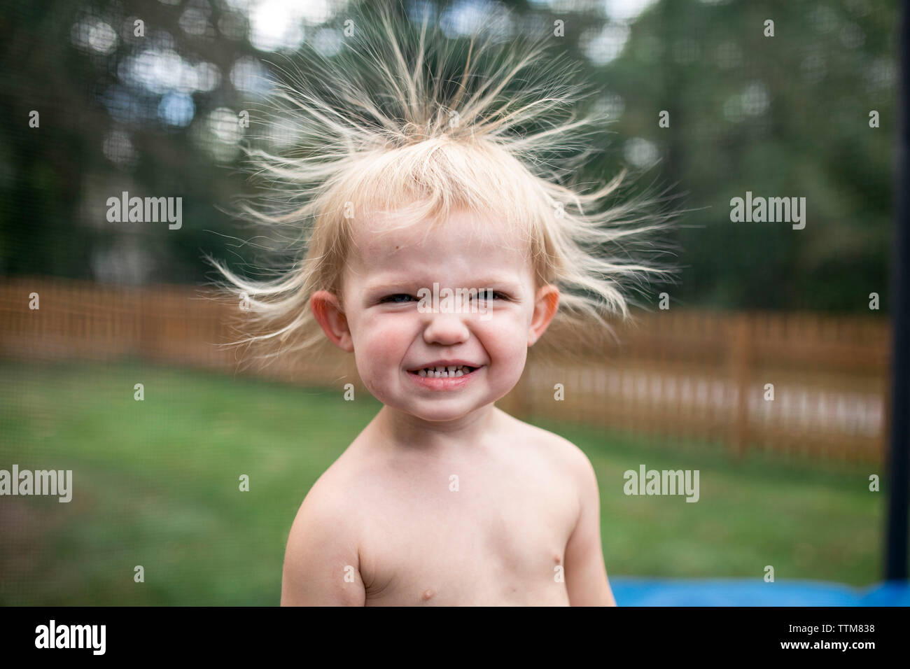 close up of smiling toddler girl with static hair outdoors Stock Photo