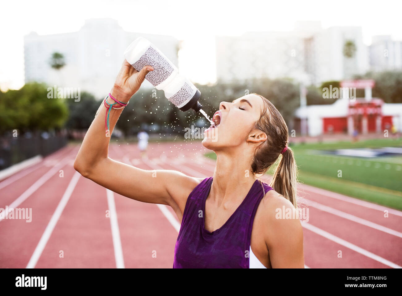 Female athlete drinking water on race tracks Stock Photo Alamy