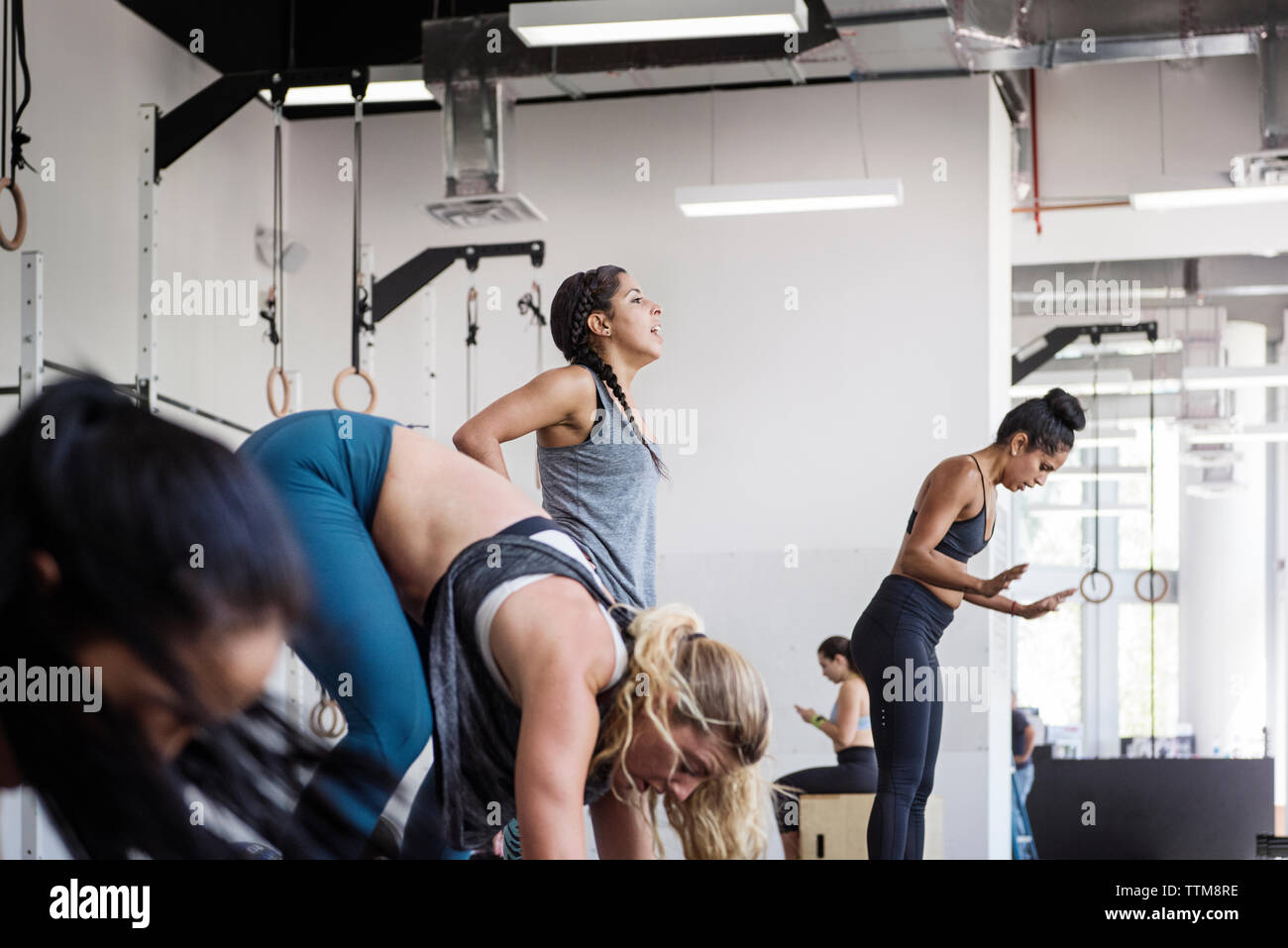 Female athletes doing burpee exercise in crossfit gym Stock Photo