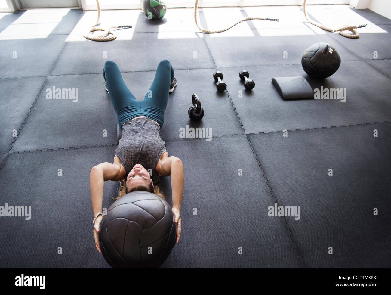 Focused athlete exercising with medicine ball in crossfit gym Stock