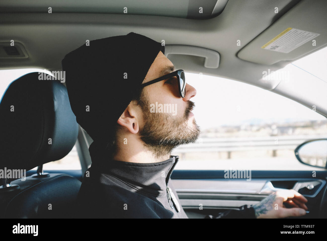 Side view of man wearing knit hat while driving car Stock Photo Alamy
