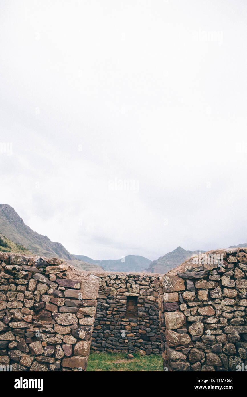 Old ruin by mountains against cloudy sky Stock Photo