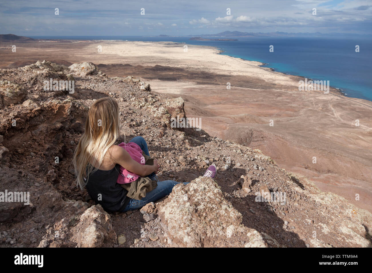 20 30 yrs old blonde girl admiring panorama from summit of a volcano Stock Photo