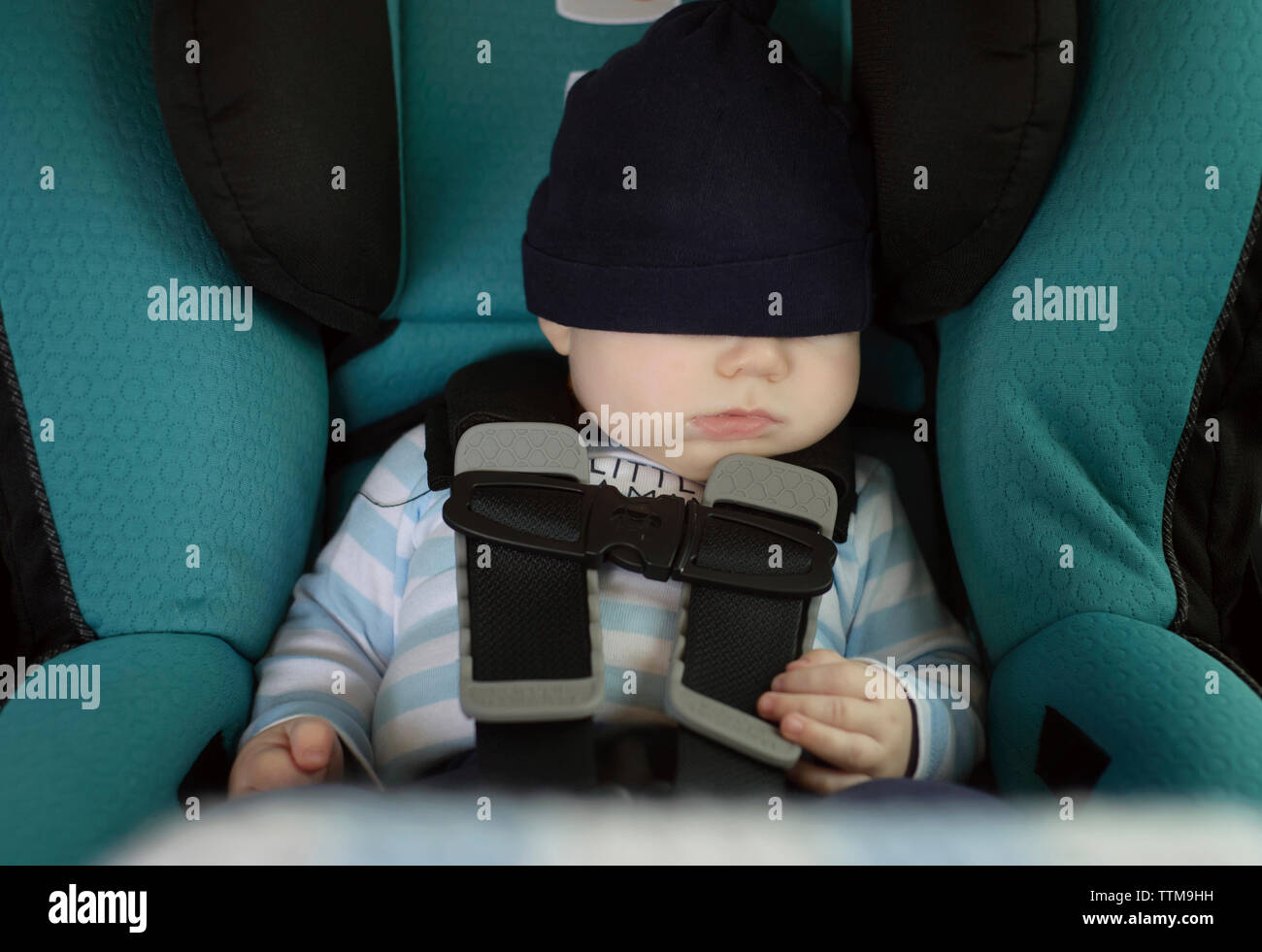 Baby boy sleeping while sitting in car Stock Photo