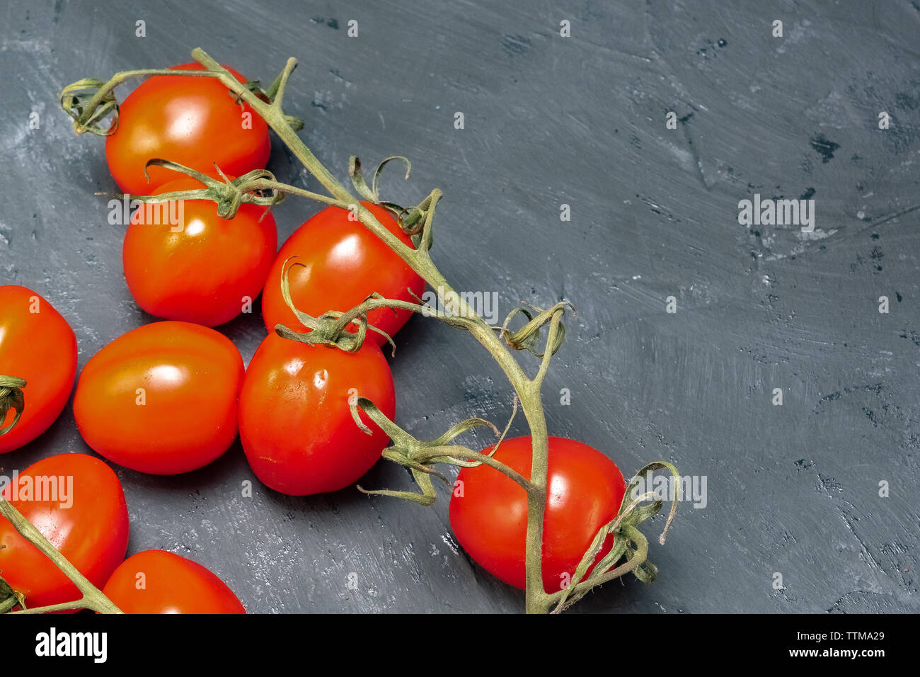 branch of tomato cherry on a black background Stock Photo - Alamy