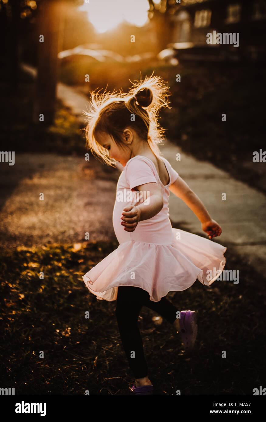 a girl does twirls in the setting sun Stock Photo