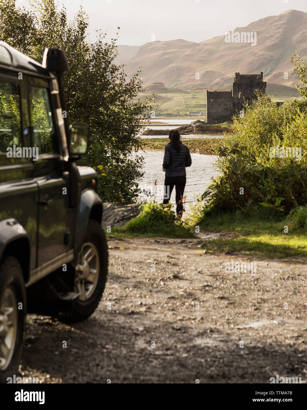 Rear view of woman standing at riverbank Stock Photo - Alamy