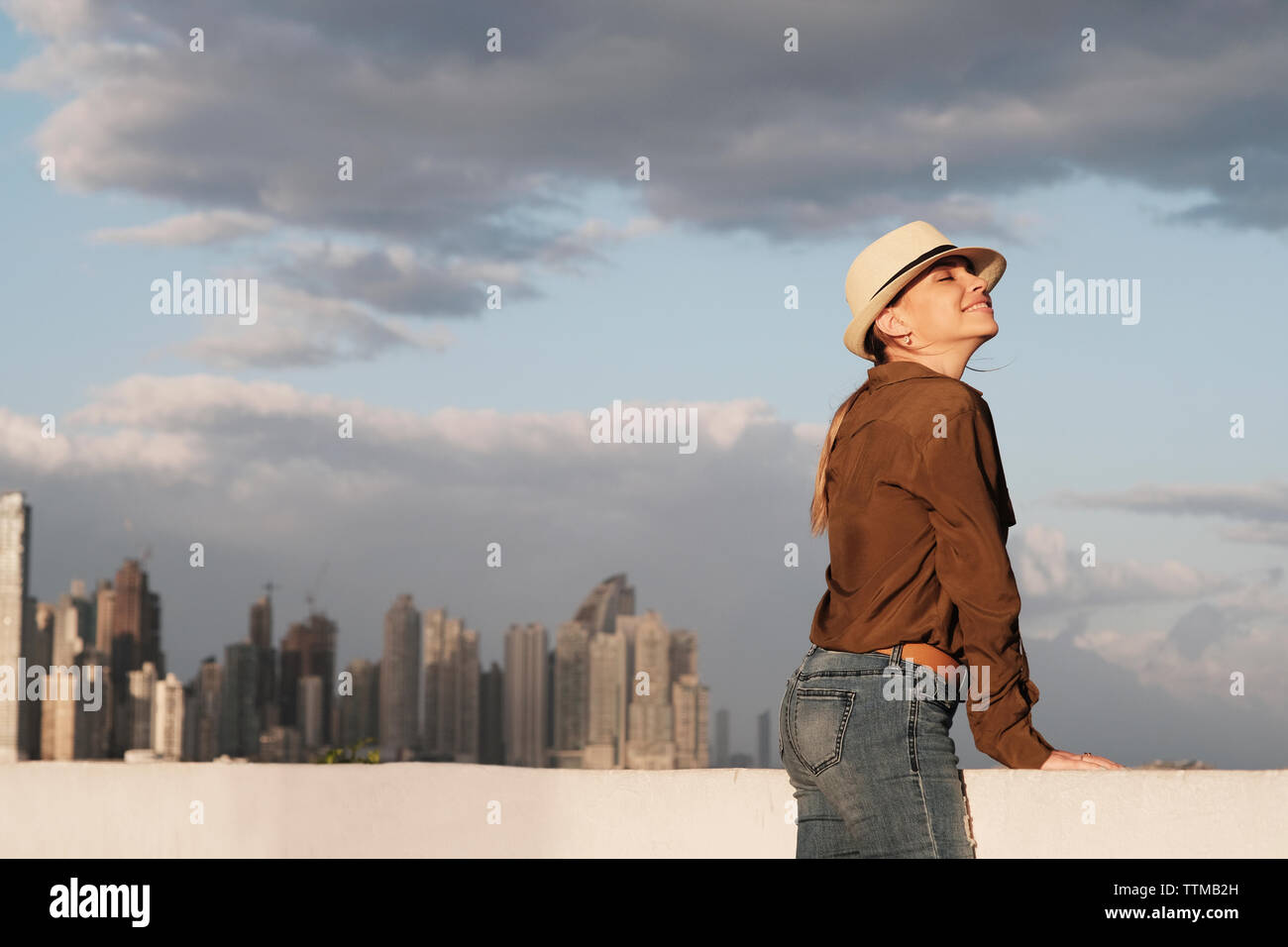 City Skyline and Woman With Closed Eyes Breathing Fresh Air Stock Photo