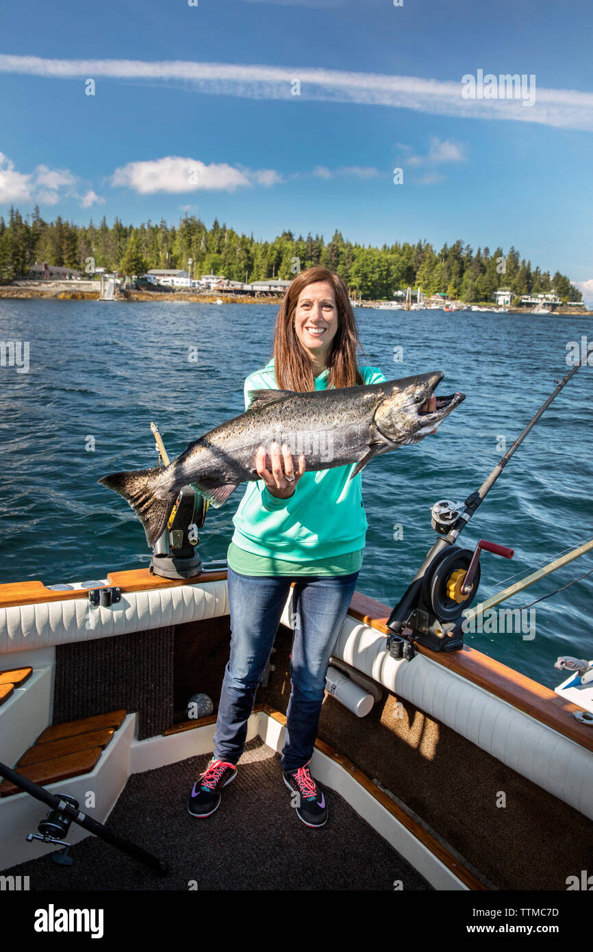 USA, Alaska, Ketchikan, a female fisherman shows off her catch while fishing the Behm Canal near Clarence Straight, Knudsen Cove along the Tongass Nar Stock Photo