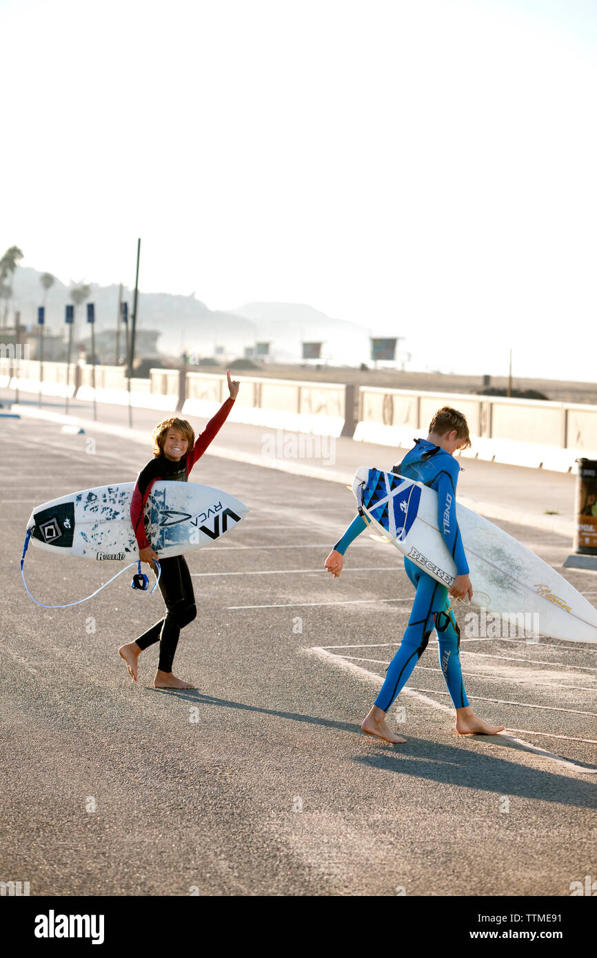 USA, California, Malibu, young surfer boys are excited to go surfing at