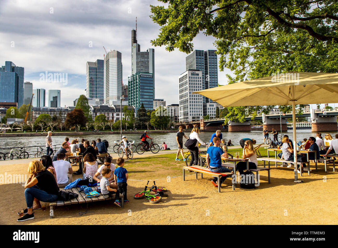 Frankfurt am Main, Blick auf die Skyline der Innenstadt, vom Linken Mainufer, Uferweg, Biergarten, Leute chillen am Ufer, Stock Photo