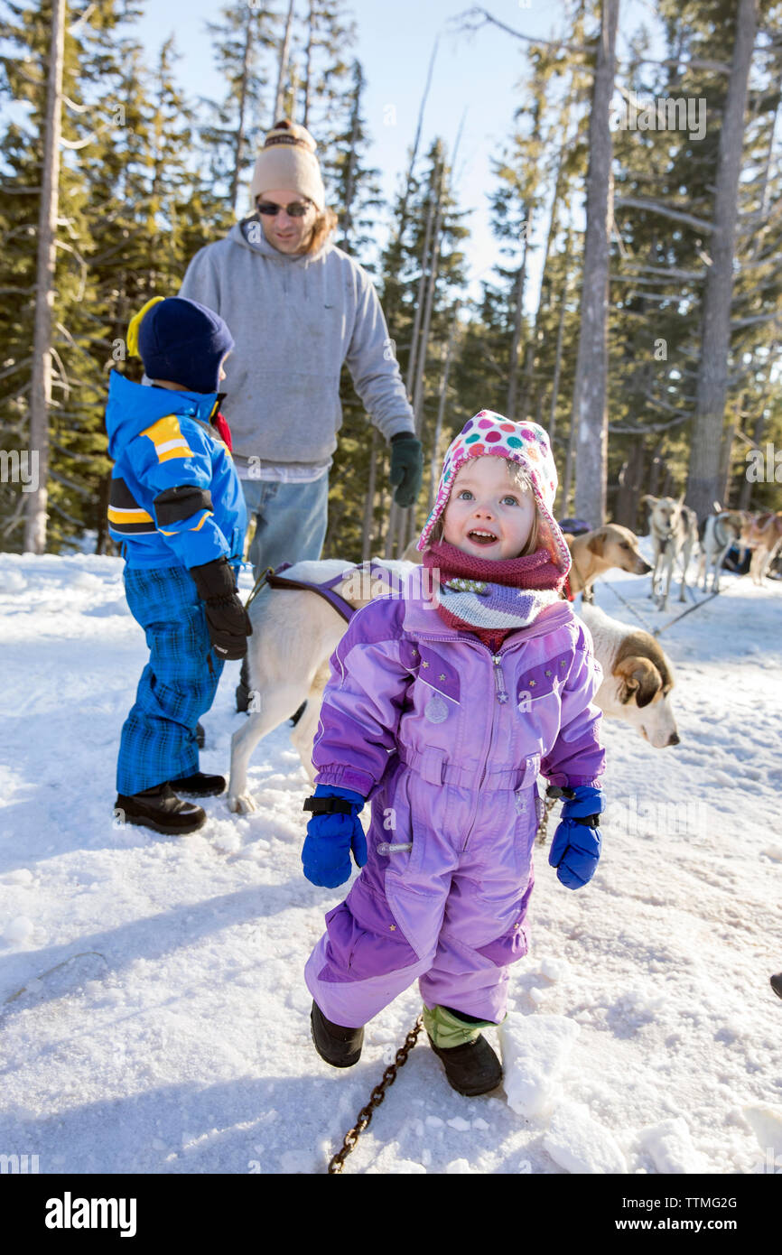 USA, Oregon, Bend, a young boy and girl play with the sled dogs at Mt