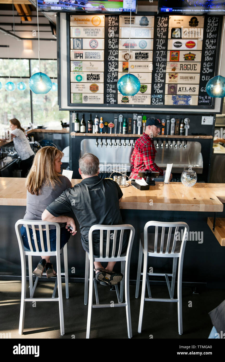 USA, Oregon, Bend, Pacific Pizza and Brew, couple at bar Stock Photo
