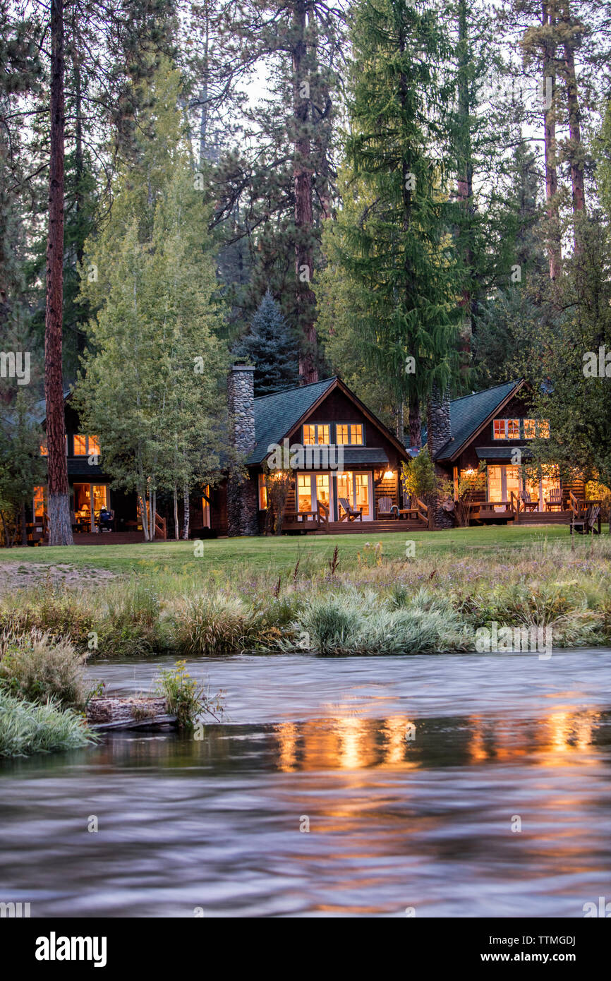 USA, Oregon, Camp Sherman, Metolius River Resort, View of cabins from River Stock Photo
