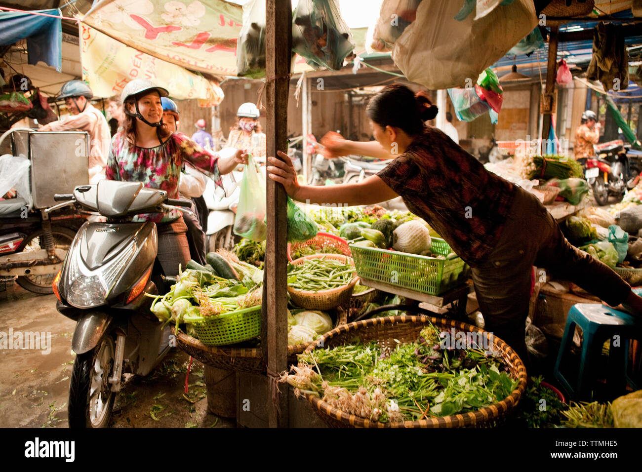 VIETNAM, Hanoi, a woman and son on their moped buy vegetables in the Chau  Long Market Stock Photo - Alamy