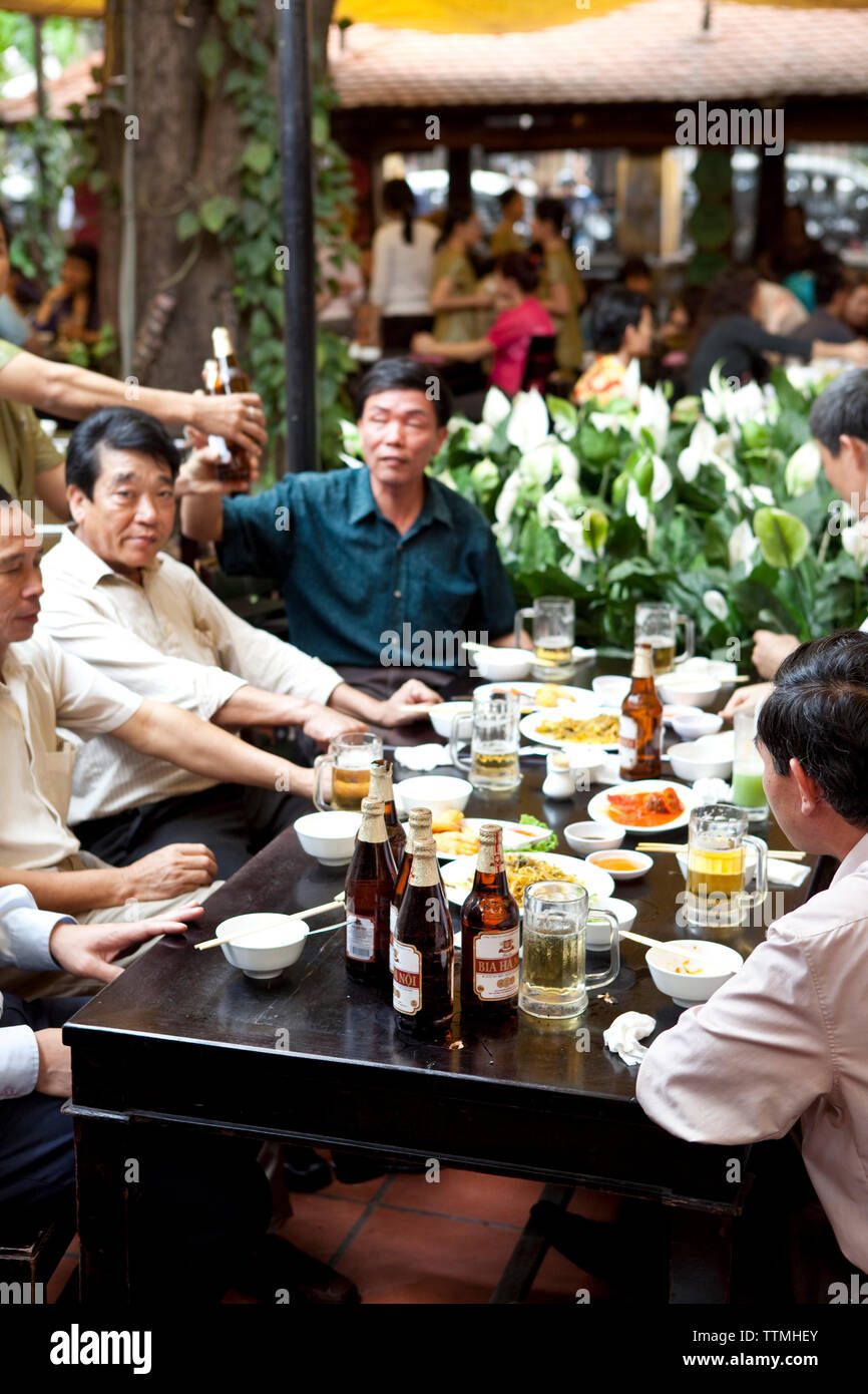 VIETNAM, Hanoi, men drink and eat lunch at a traditional street food restaurant called Quan An Ngon Stock Photo