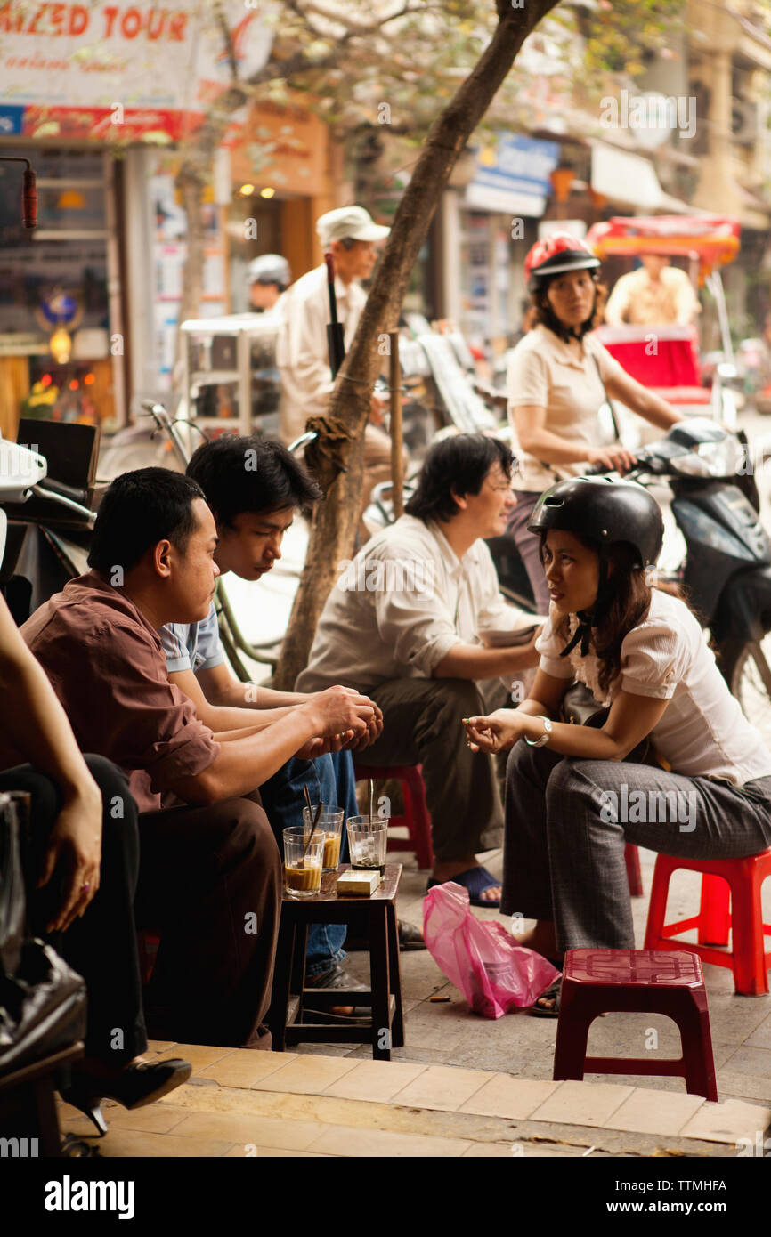 VIETNAM, Hanoi, friends socialize and drink coffee at a